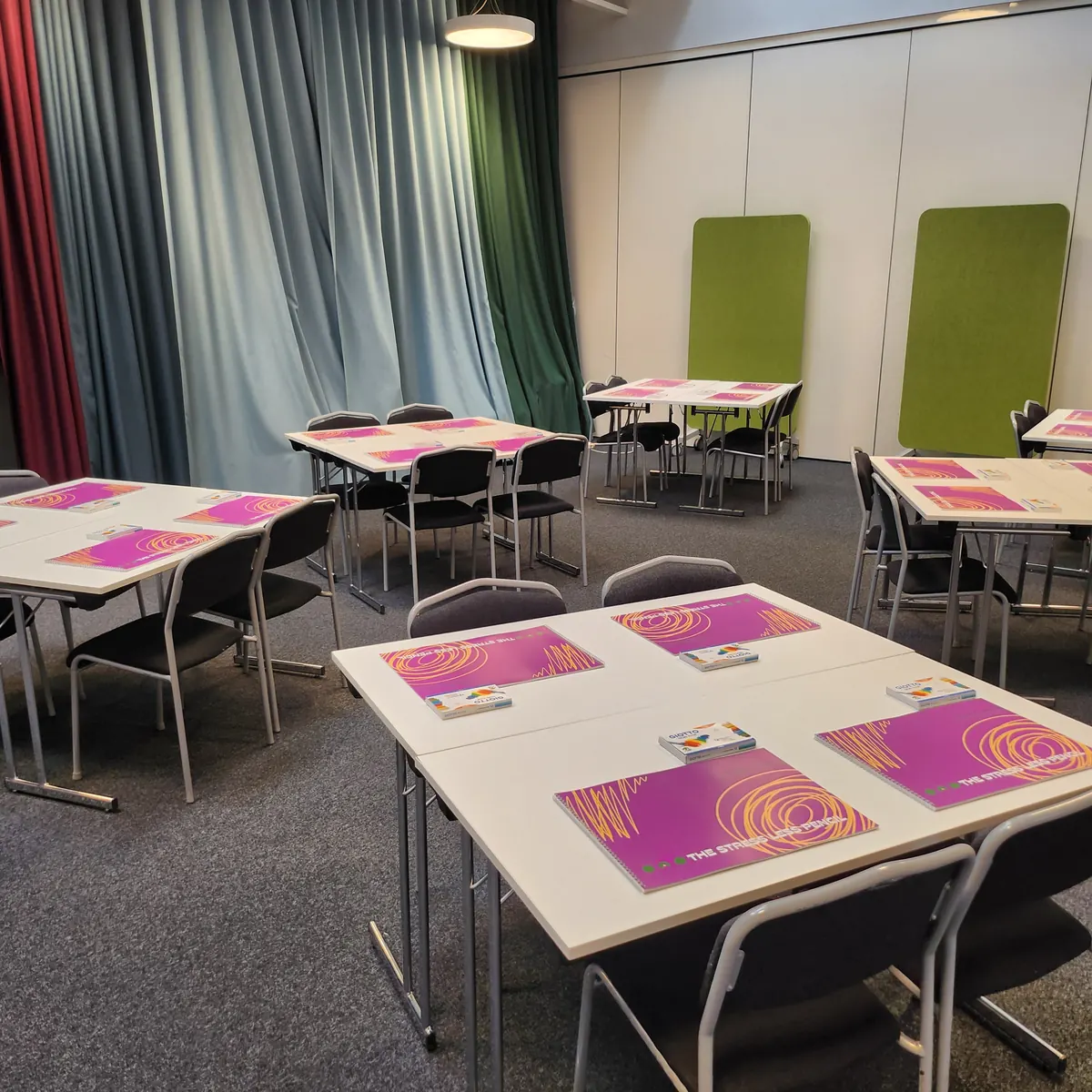 Bord förberedda med ritpapper och färger inför ett kreativt teamevent hos kund.
