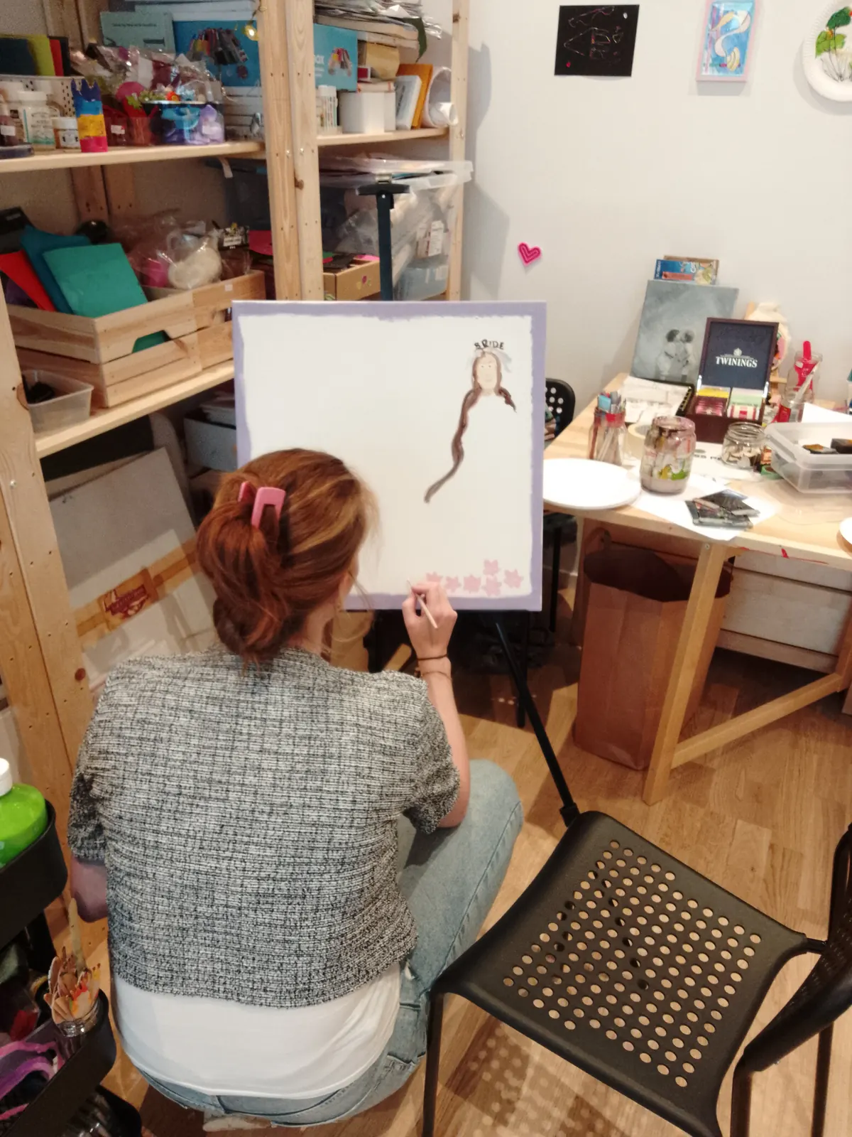 En deltagare målar en brudtavla på staffli under en kreativ möhippa i Kungälv.