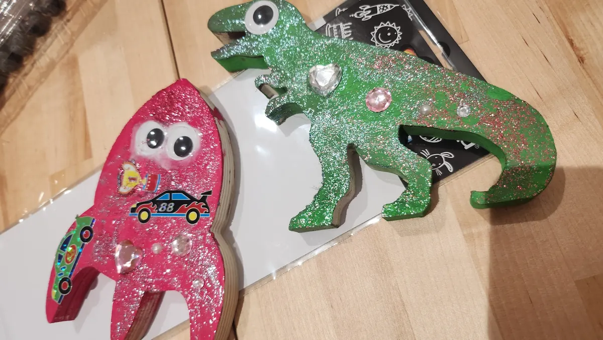 Glitter-decorated wooden rocket and dinosaur – crafts for kids’ parties in Kungälv.