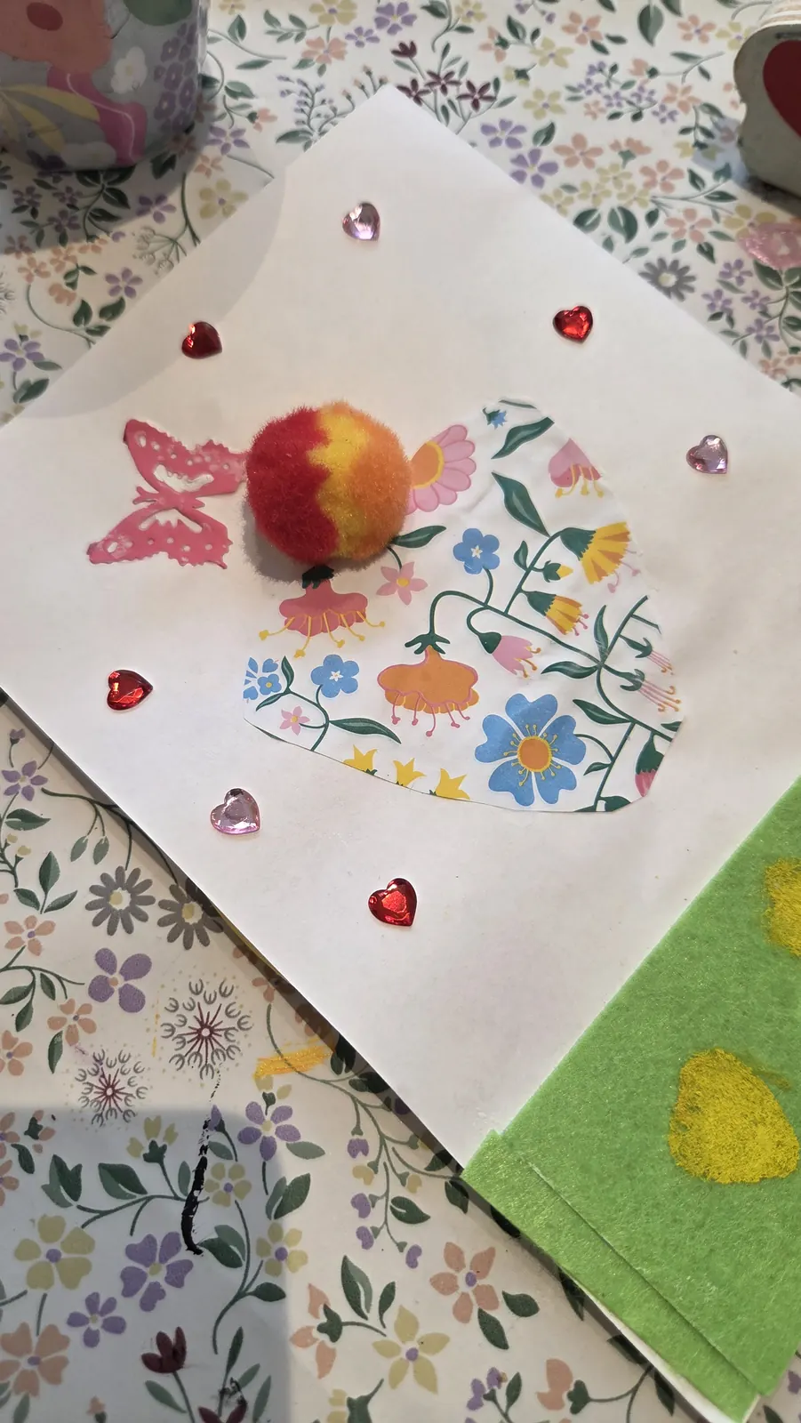 Collage med blommigt papper, pompong och glittriga hjärtan – pyssel för barnkalas i Kungälv.